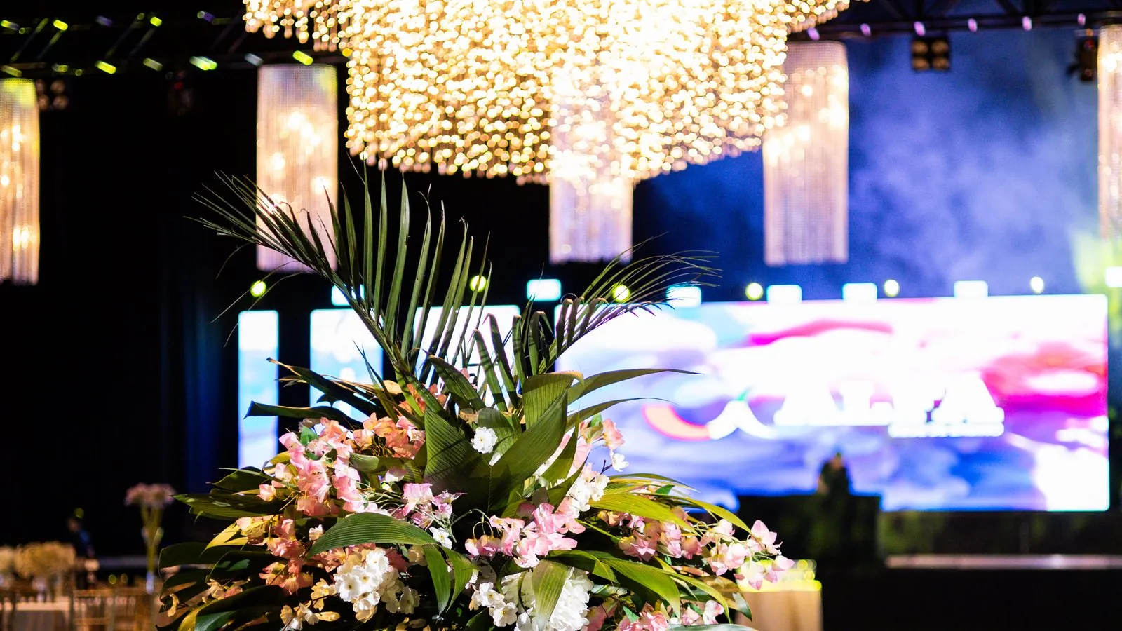 Mesa decorada de formatura com iluminacao cenica e flores