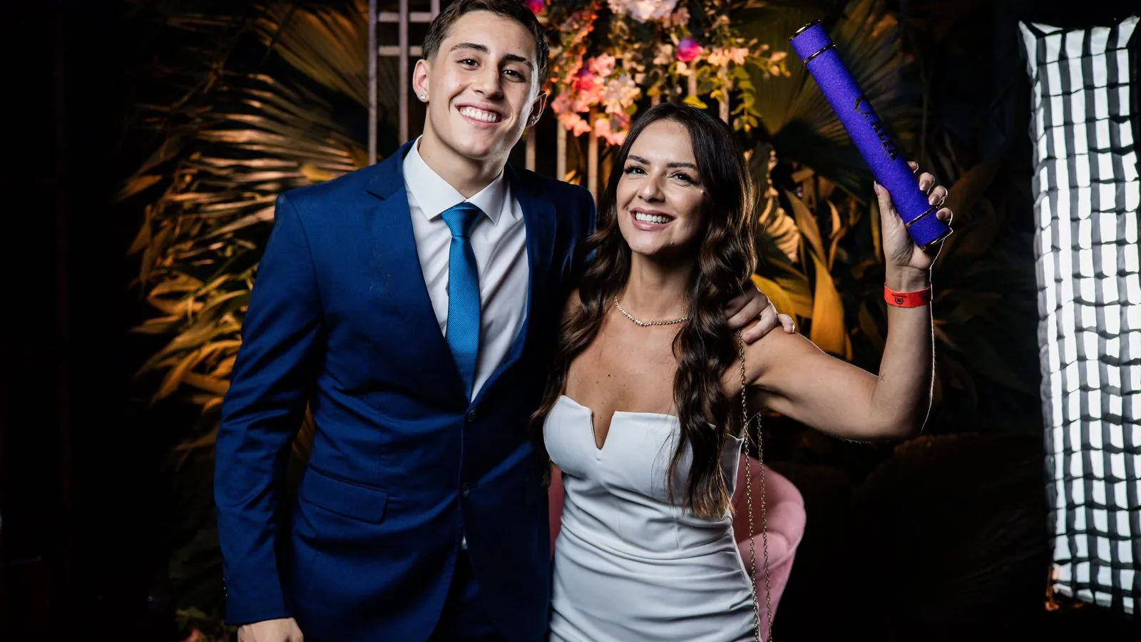 Casal sorrindo em celebracao de formatura com decoracao elegante
